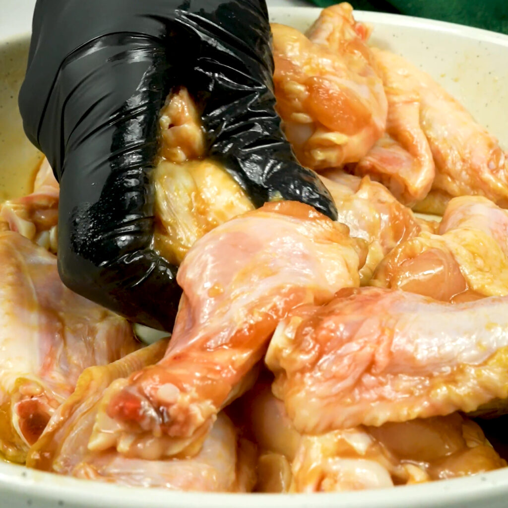 Marinating chicken wings in a bowl.