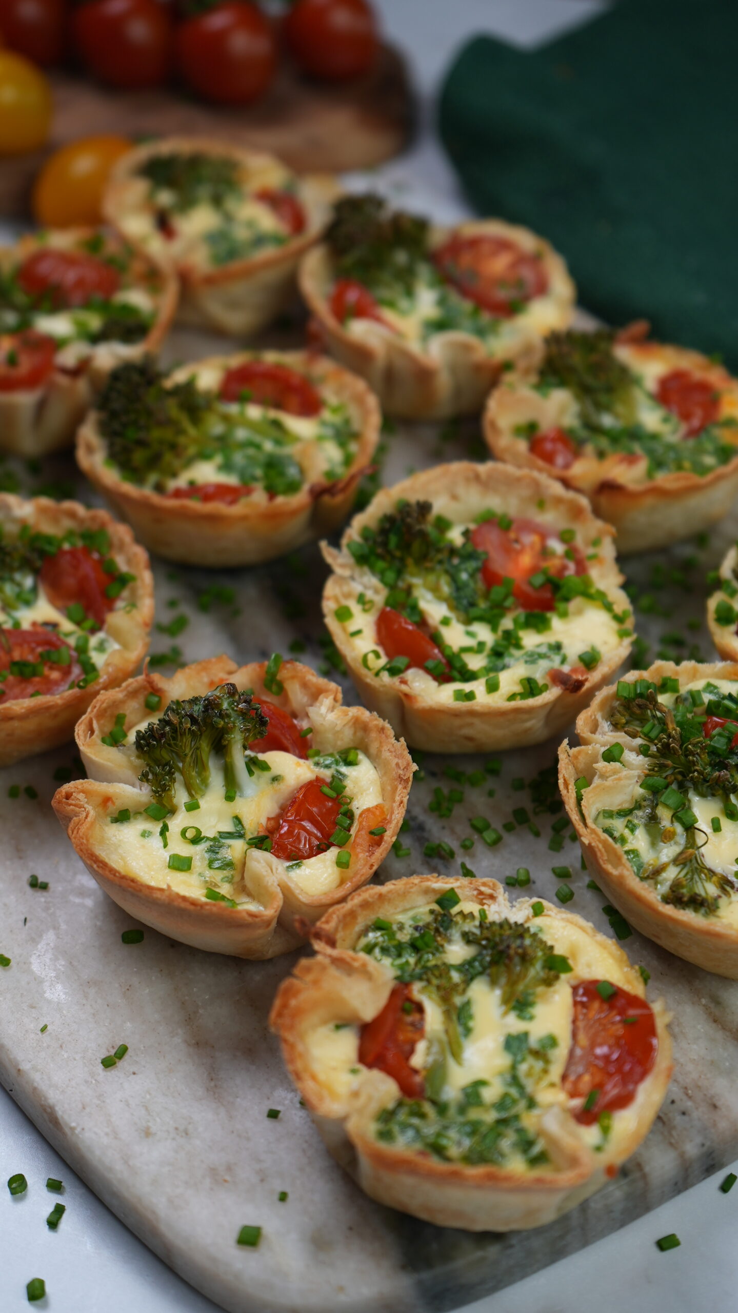 Mini Tortilla Quiches with crispy tortilla bases filled with mozzarella, cherry tomatoes, and broccolini.