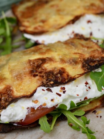 Crispy potato wrap filled with creamy burrata, fresh rocket, tomato slices, and vibrant pesto.