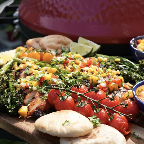 Grilled chipotle chicken served with mango salsa, warm pita bread, and grilled vegetables.