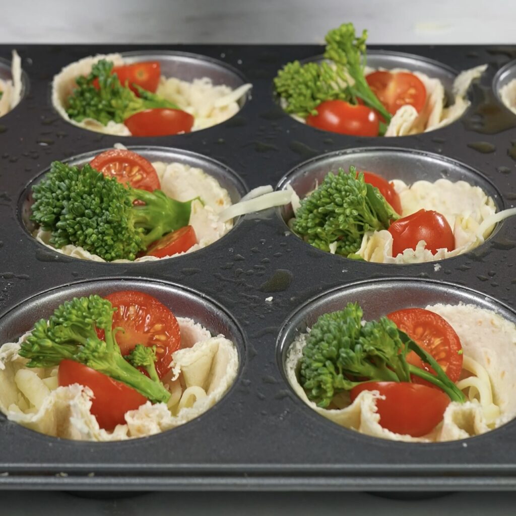 Vegetables placed in tortilla cups for mini quiches.