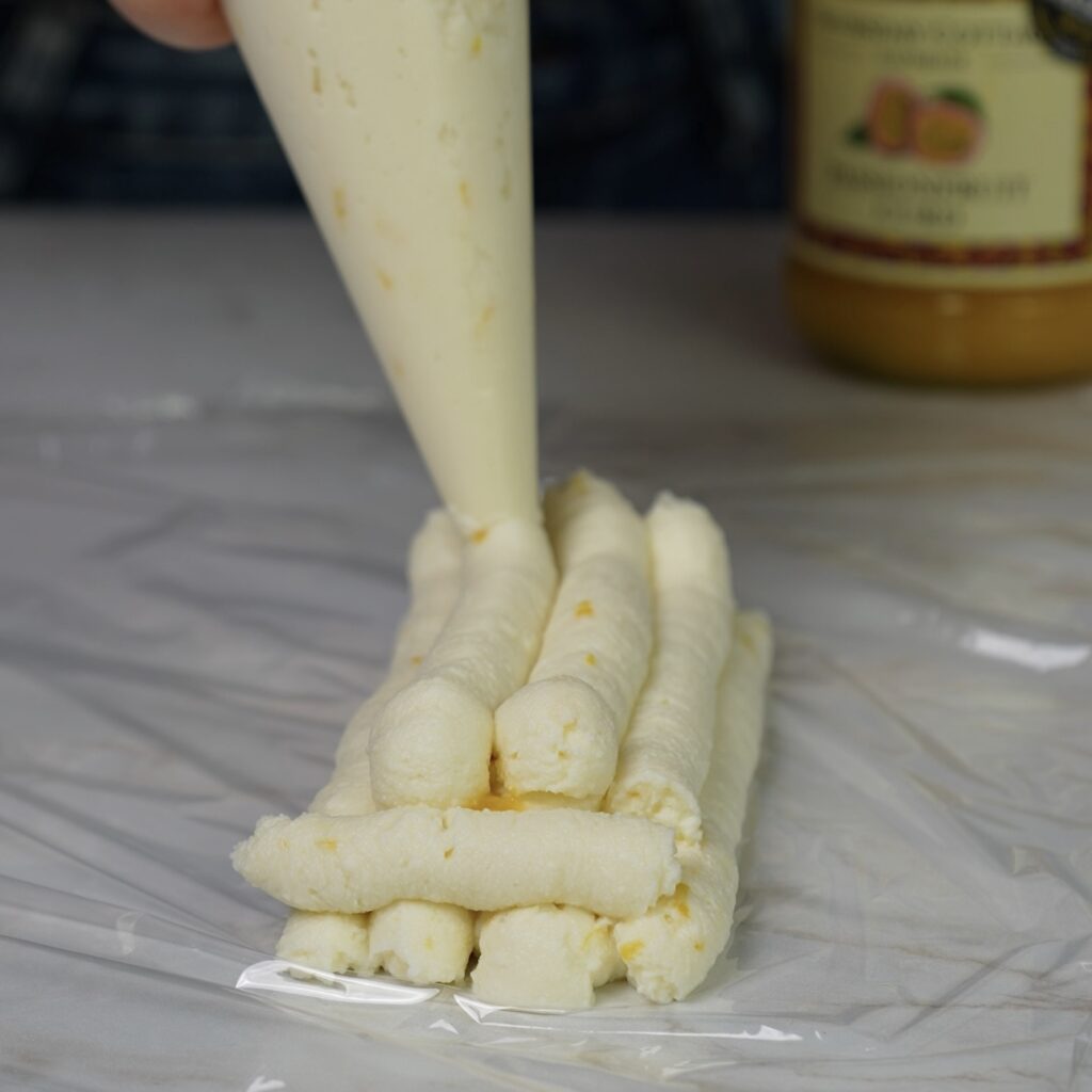 Adding a layer of ricotta over passion fruit curd