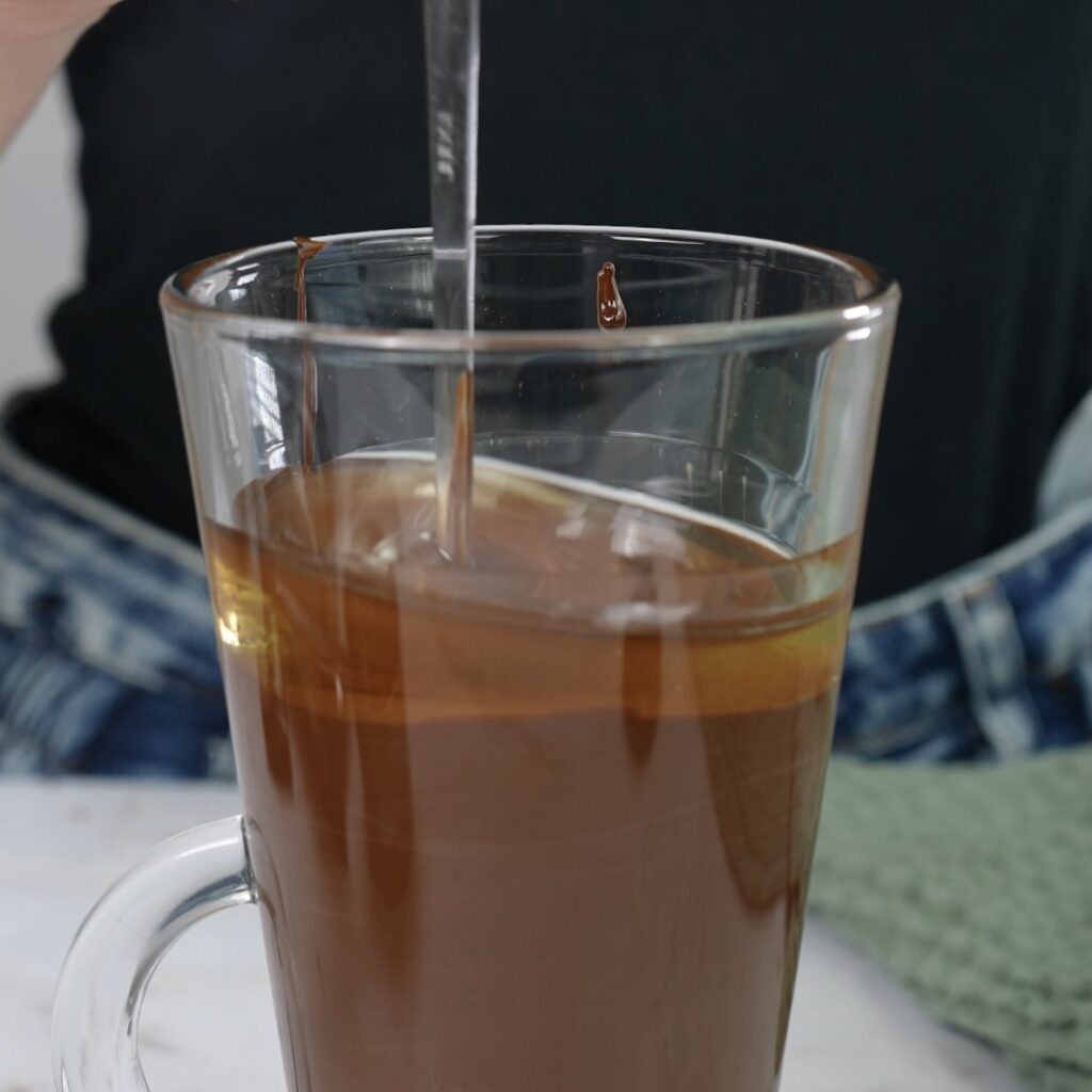 Mixing melted chocolate with oil to prepare a smooth chocolate glaze.