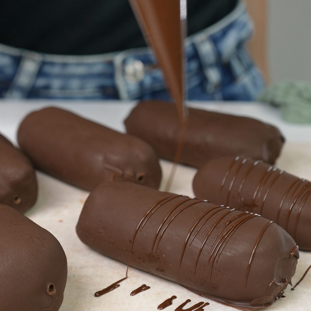 Creating a decorative chocolate pattern on the Passion Fruit Ricotta Dessert (Syrok).