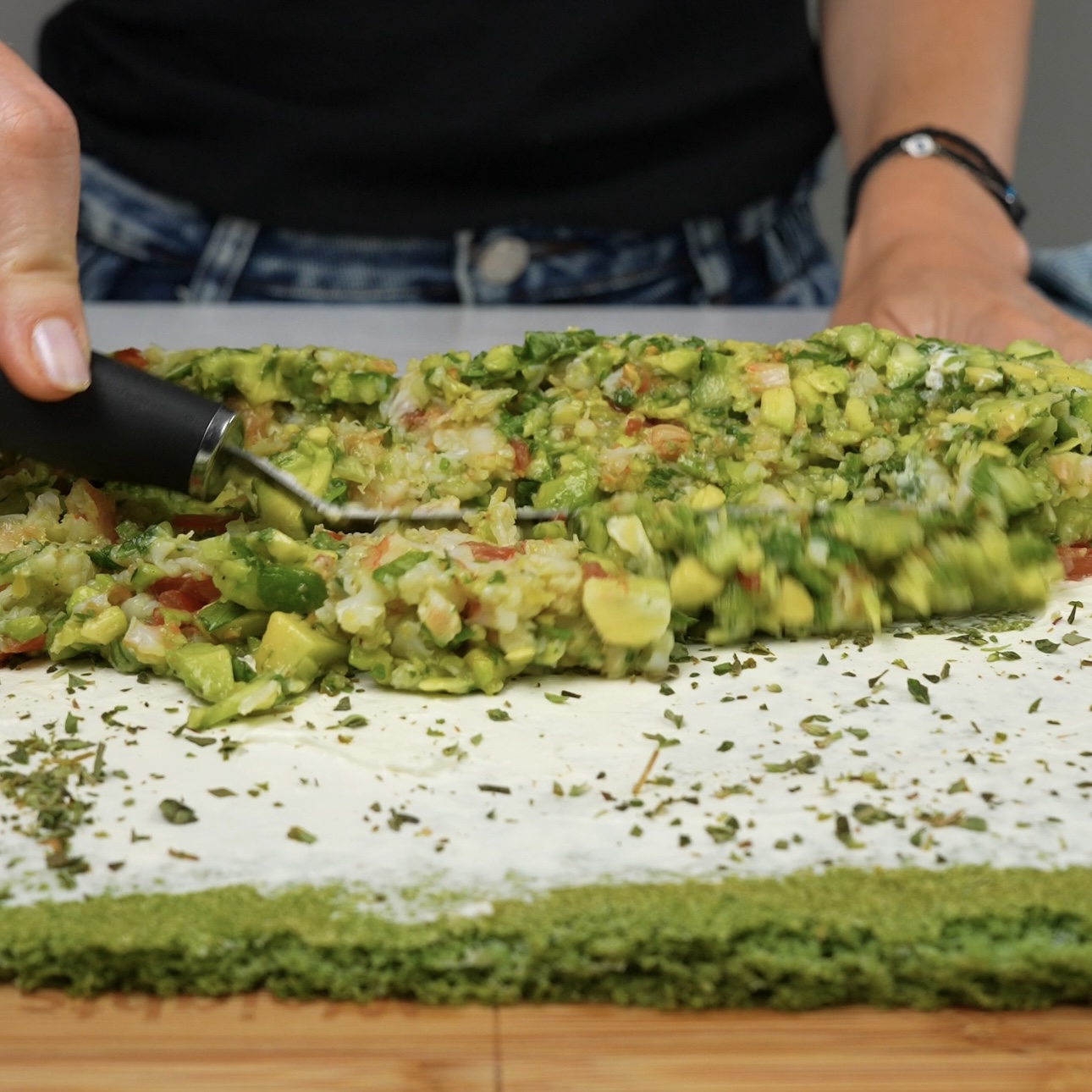 Spreading the filling mixture evenly over the spinach base.Spinach Chopped Salad Roll