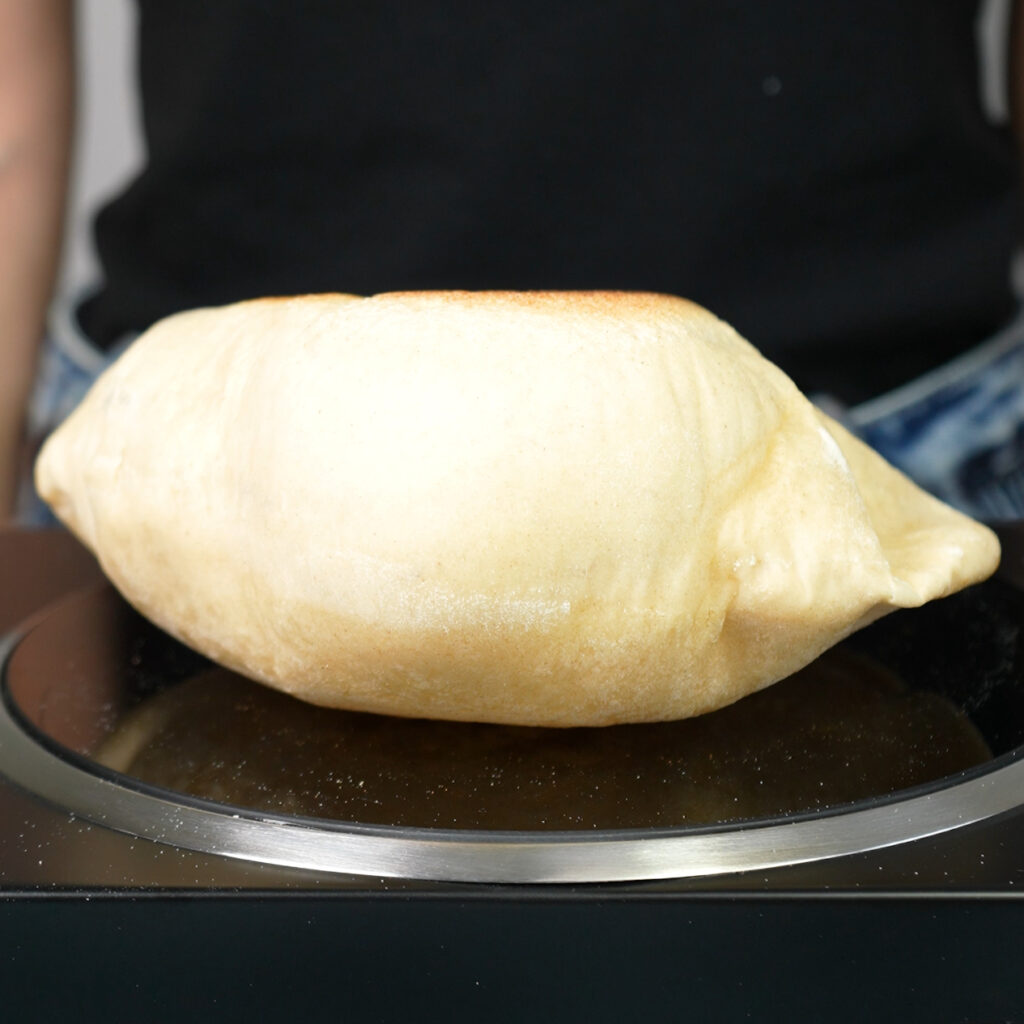 Puffed pita bread on a hot plate.