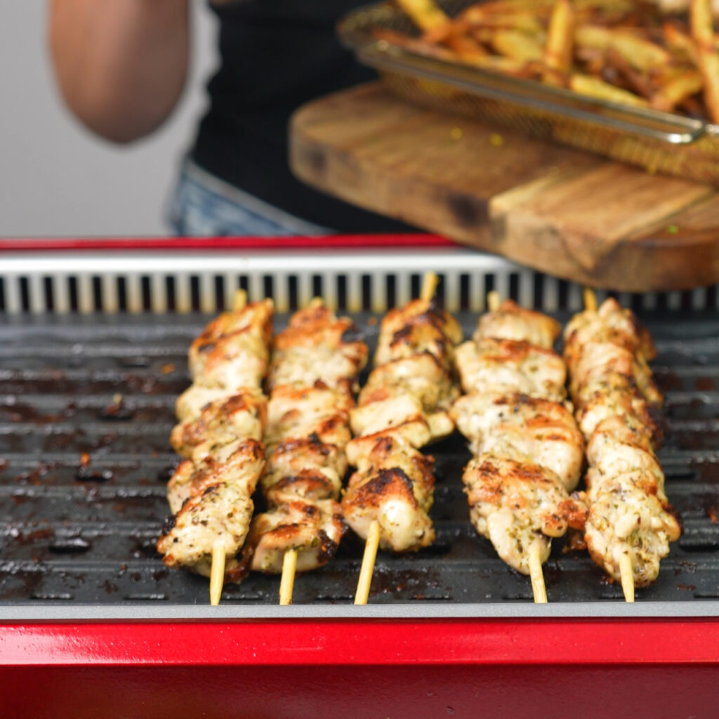 Chicken skewers cooking on the grill for Greek Chicken Souvlaki