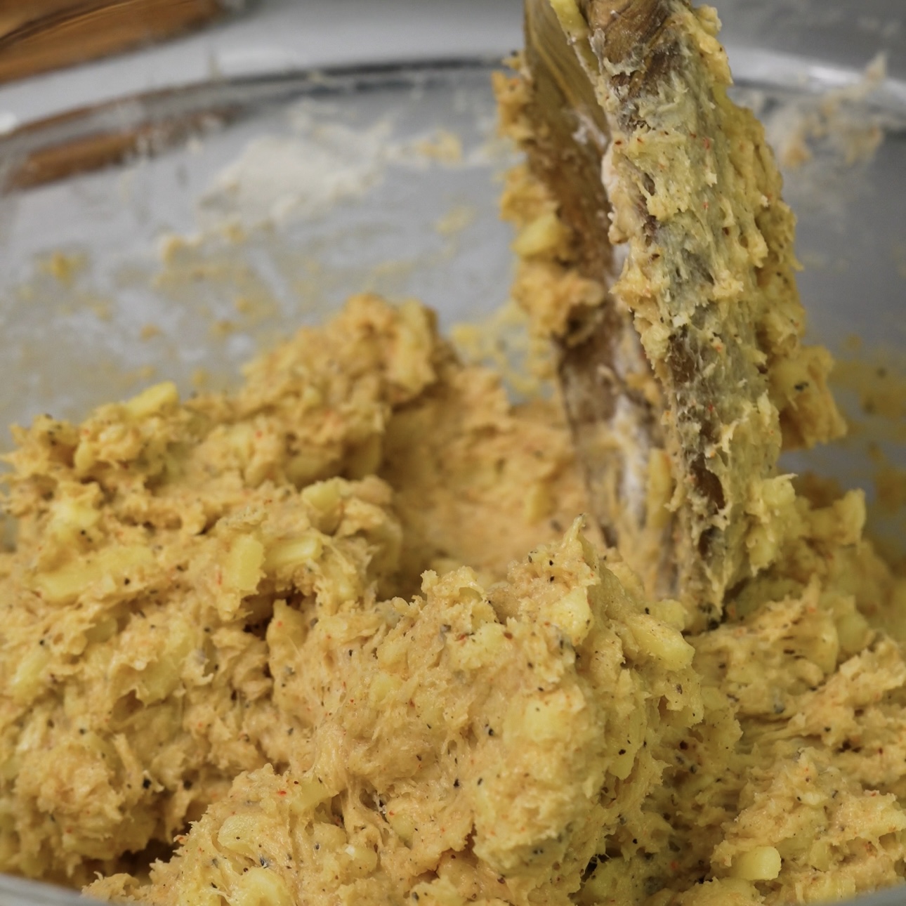 Mixing all ingredients together to form dough in a bowl.