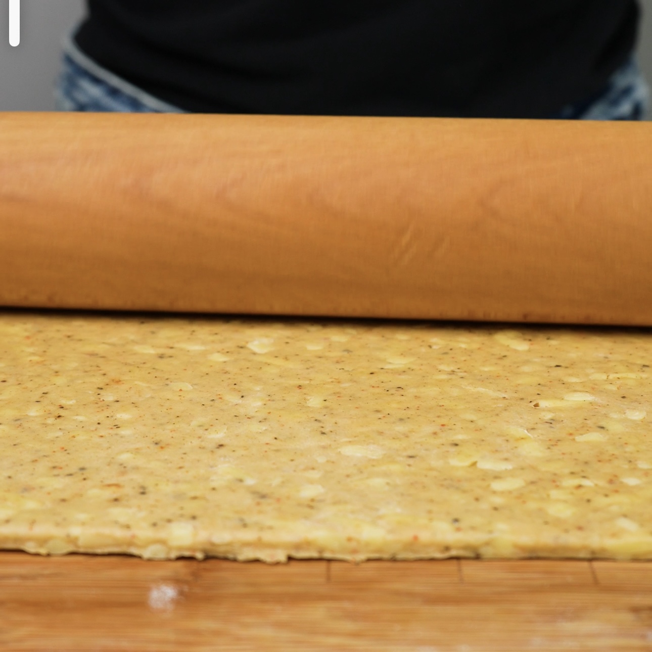 Rolled out dough in a rectangular shape, approximately 28x24 cm, on a floured surface.