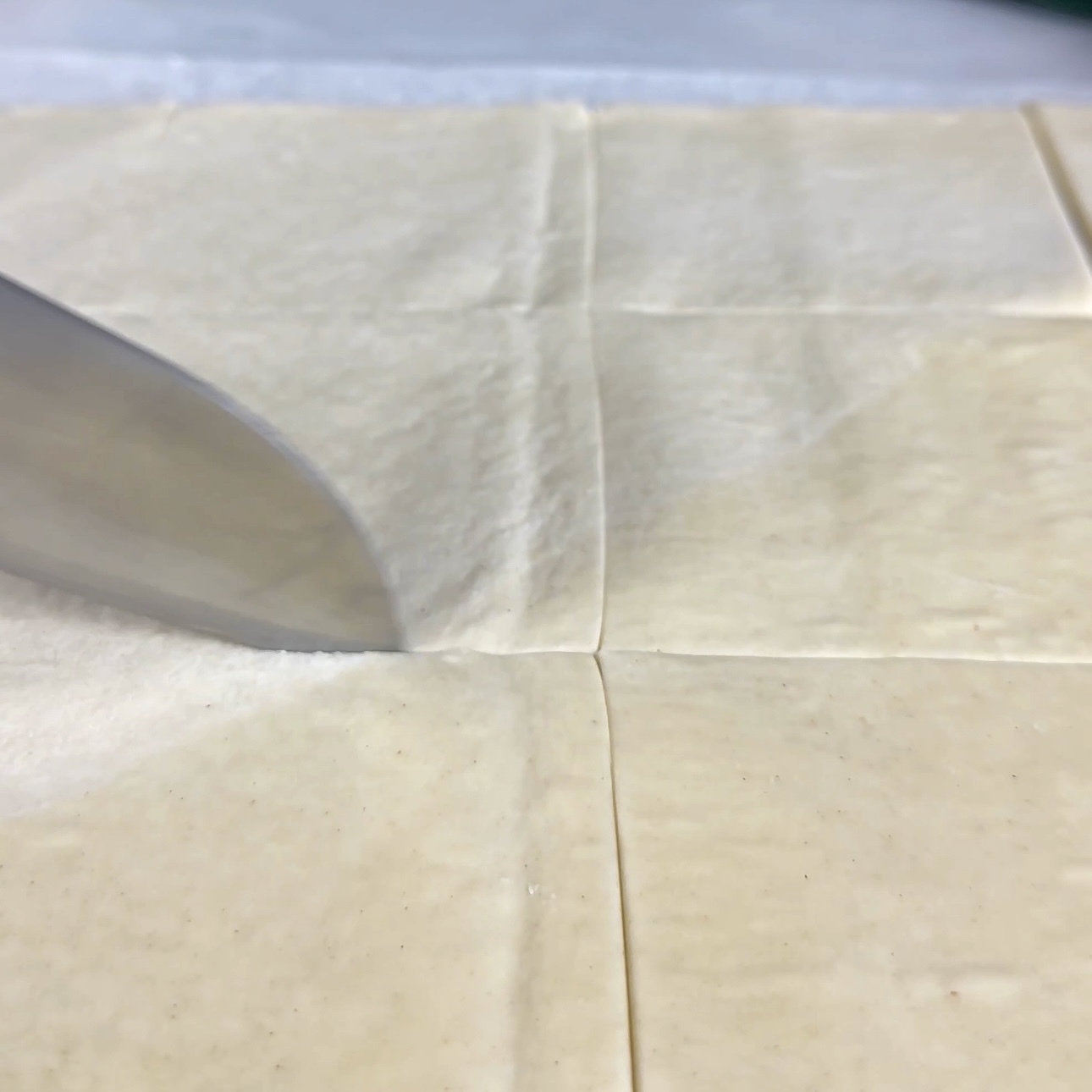 Cutting puff pastry into 12 equal squares.