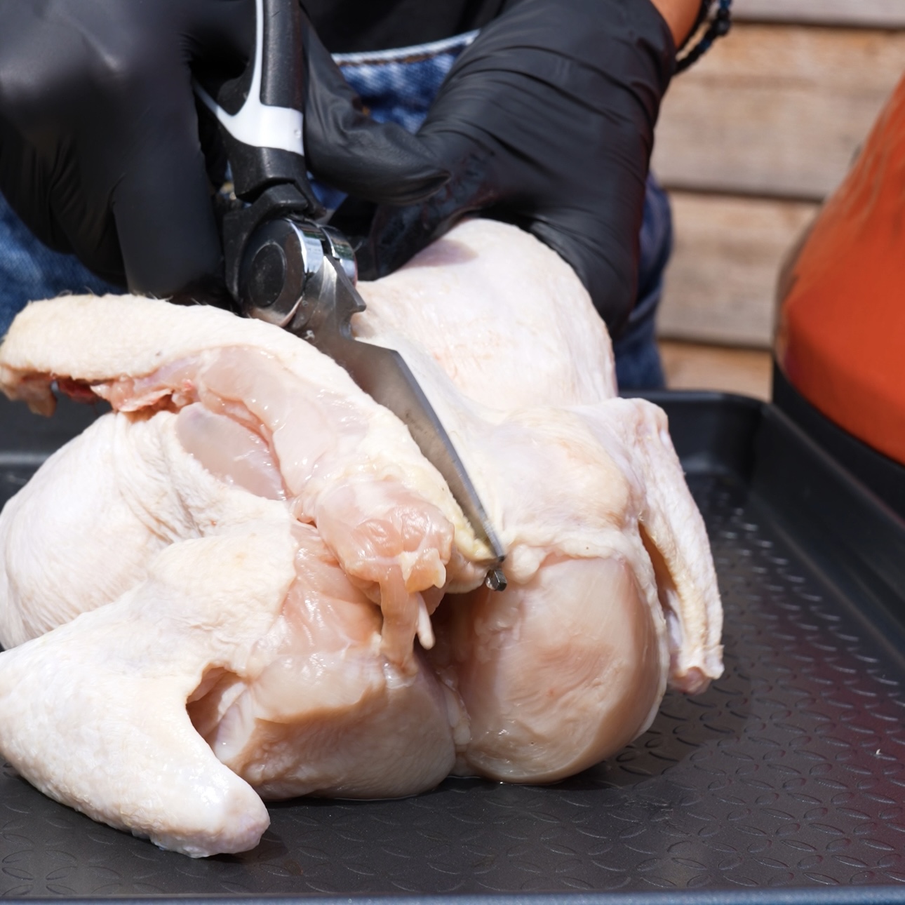 Cutting out the backbone of a chicken with kitchen shears