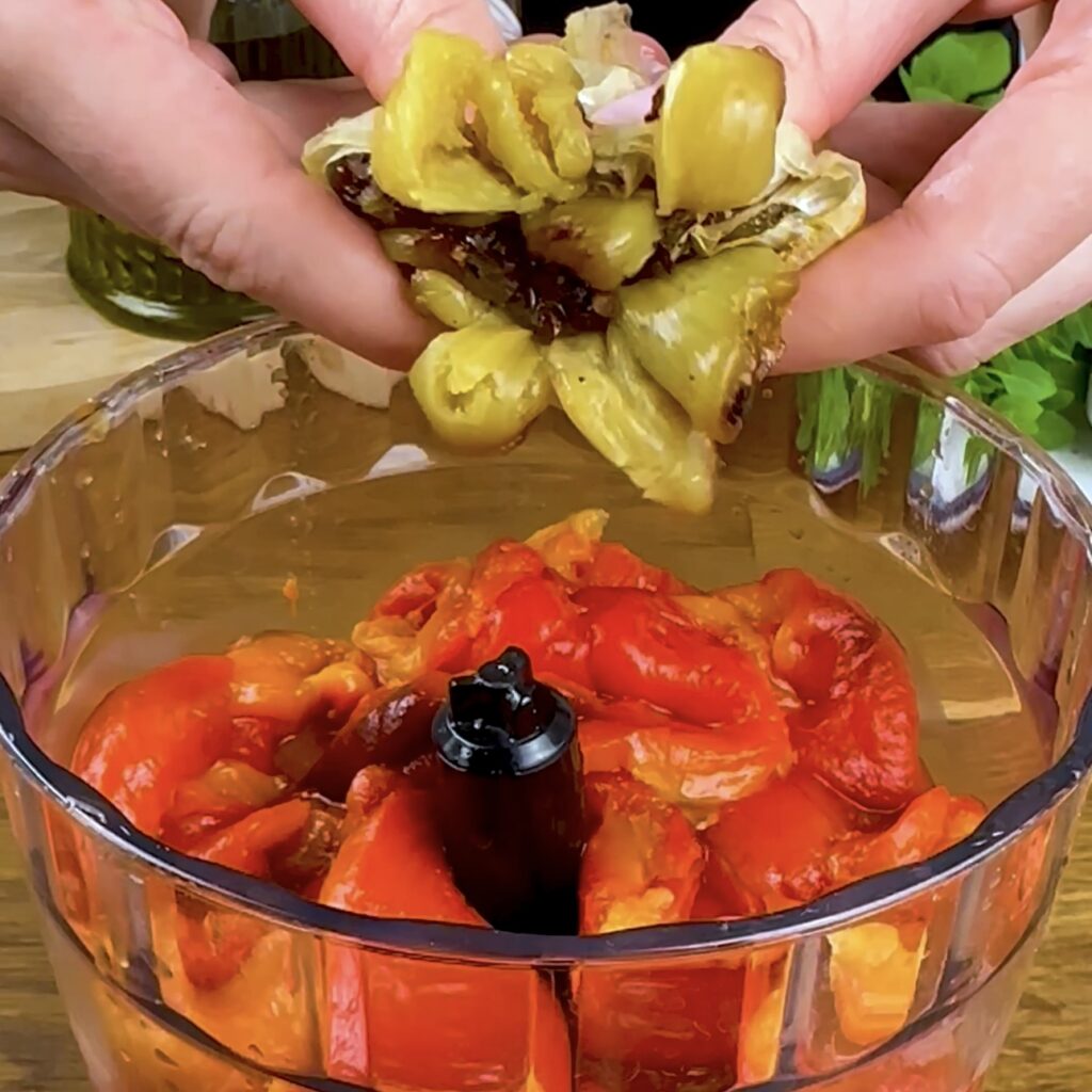 Roasted garlic is squeezed into a blender.