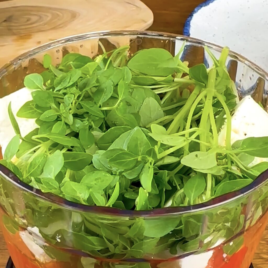 Fresh Greek basil leaves are added to a blender