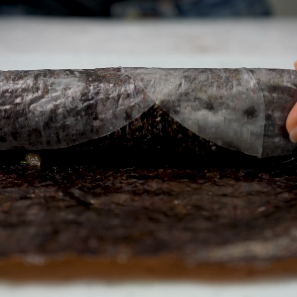 Rolling up salmon filling in nori and rice paper