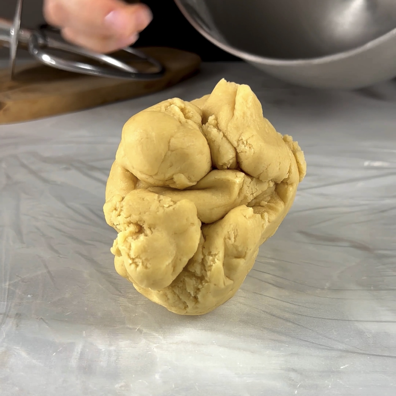 A photo of raw shortcrust pastry dough formed into a ball, ready for chilling.