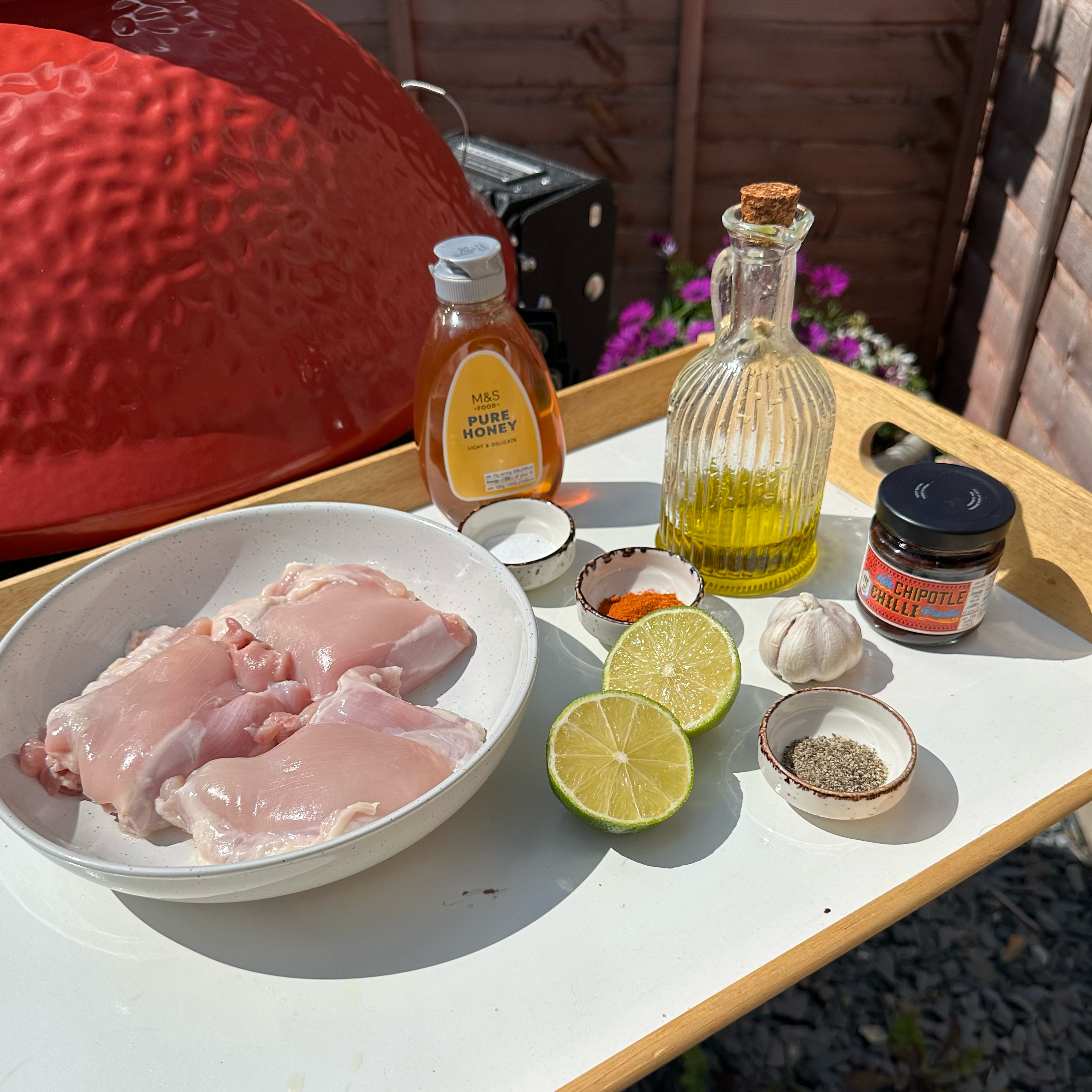 Ingredients for marinating chicken: chipotle paste, lime, honey, garlic, olive oil, paprika, salt, and pepper.