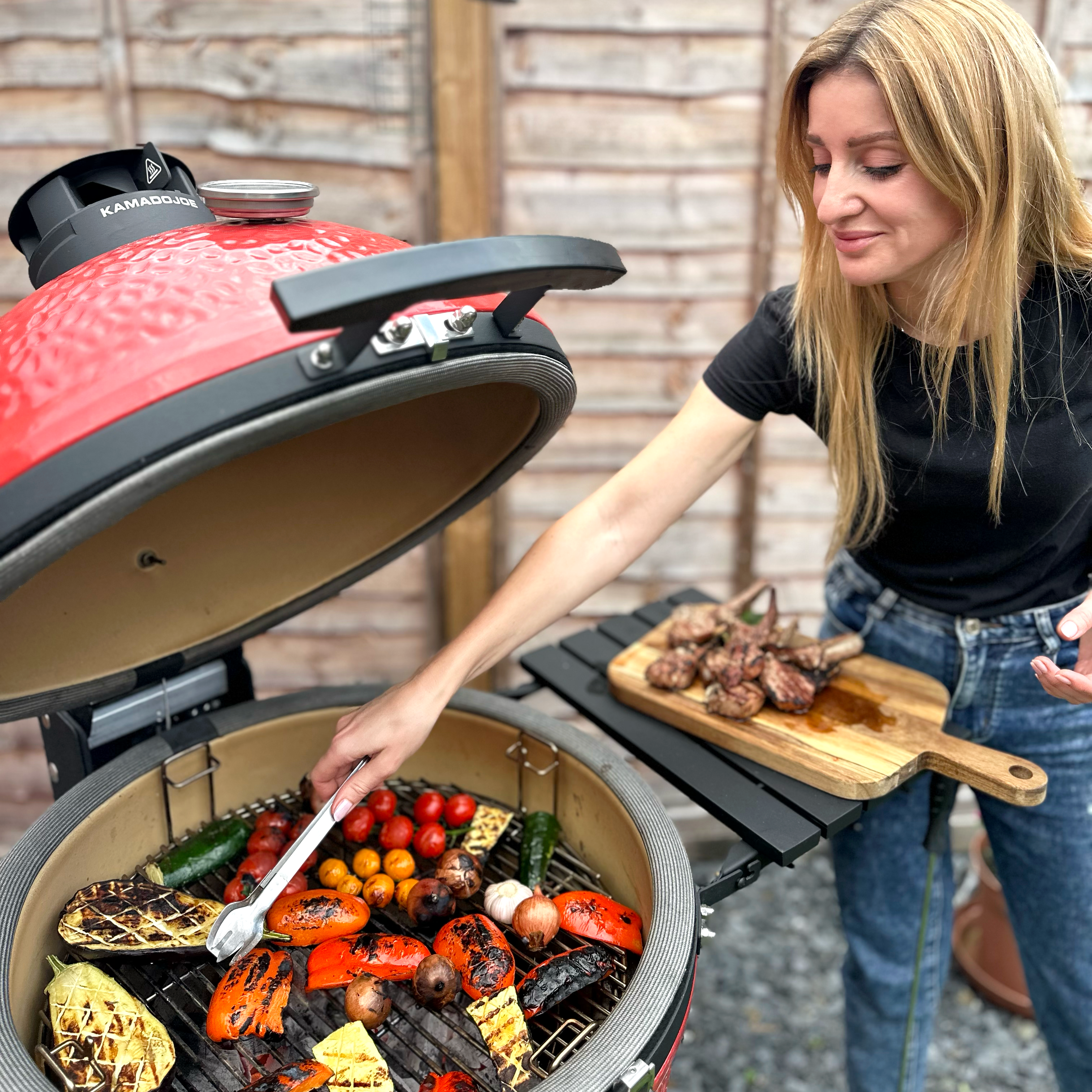 Grilling lamb chops and vegetables on a barbecue grill, with smoke rising and colorful ingredients visible.