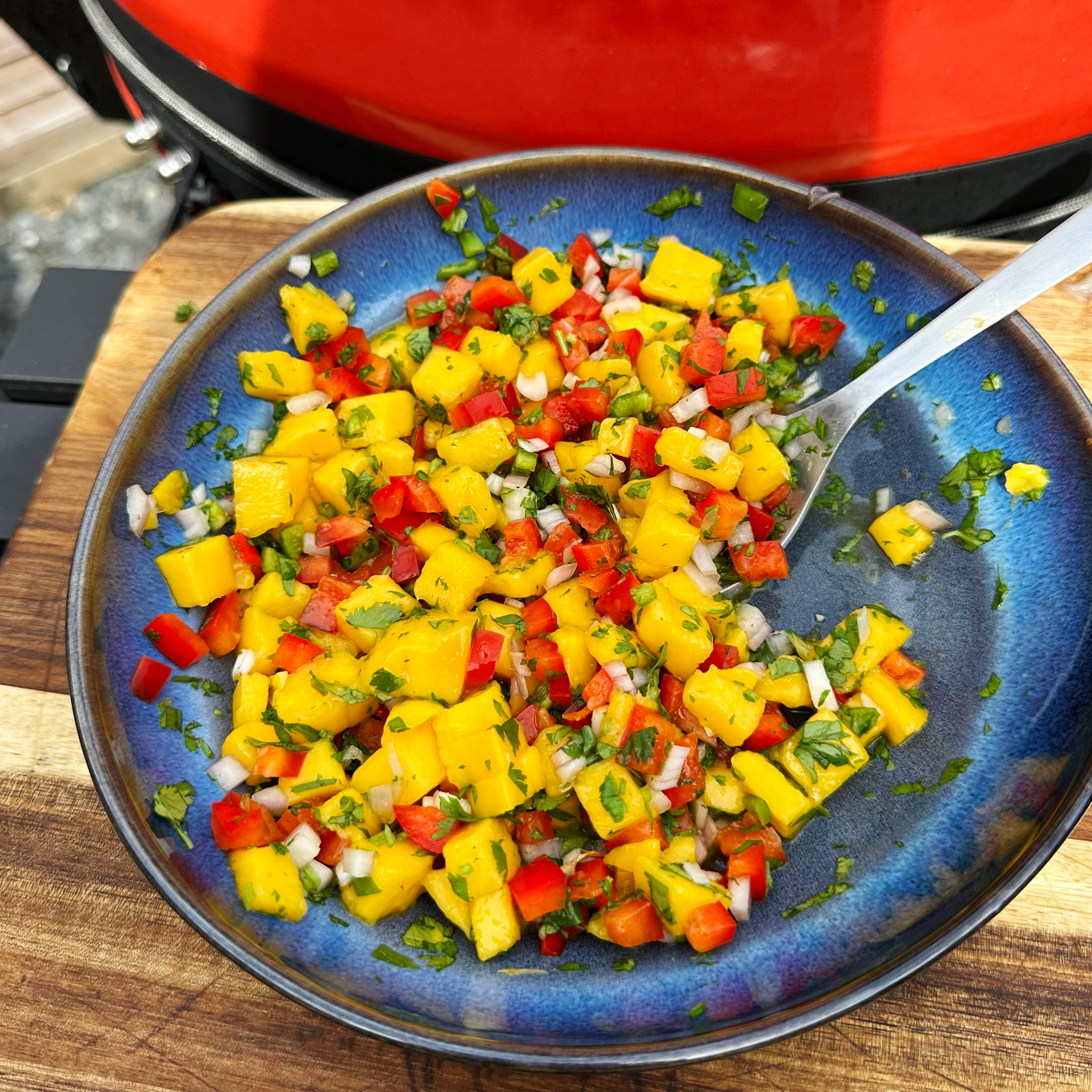 A bowl of vibrant mango salsa with diced mango, red onion, cilantro, and lime.