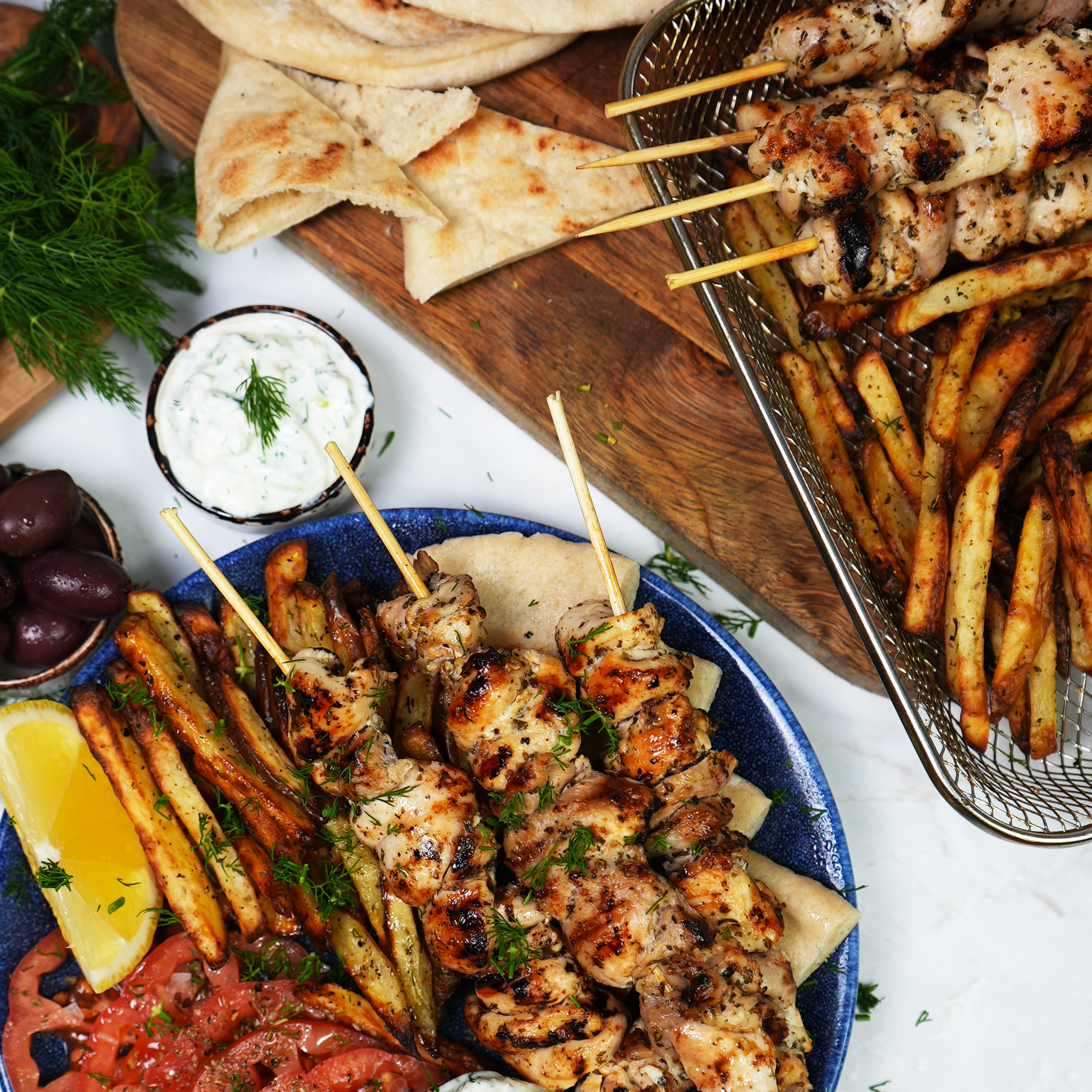 Greek chicken souvlaki skewers served on a plate with garnishes.