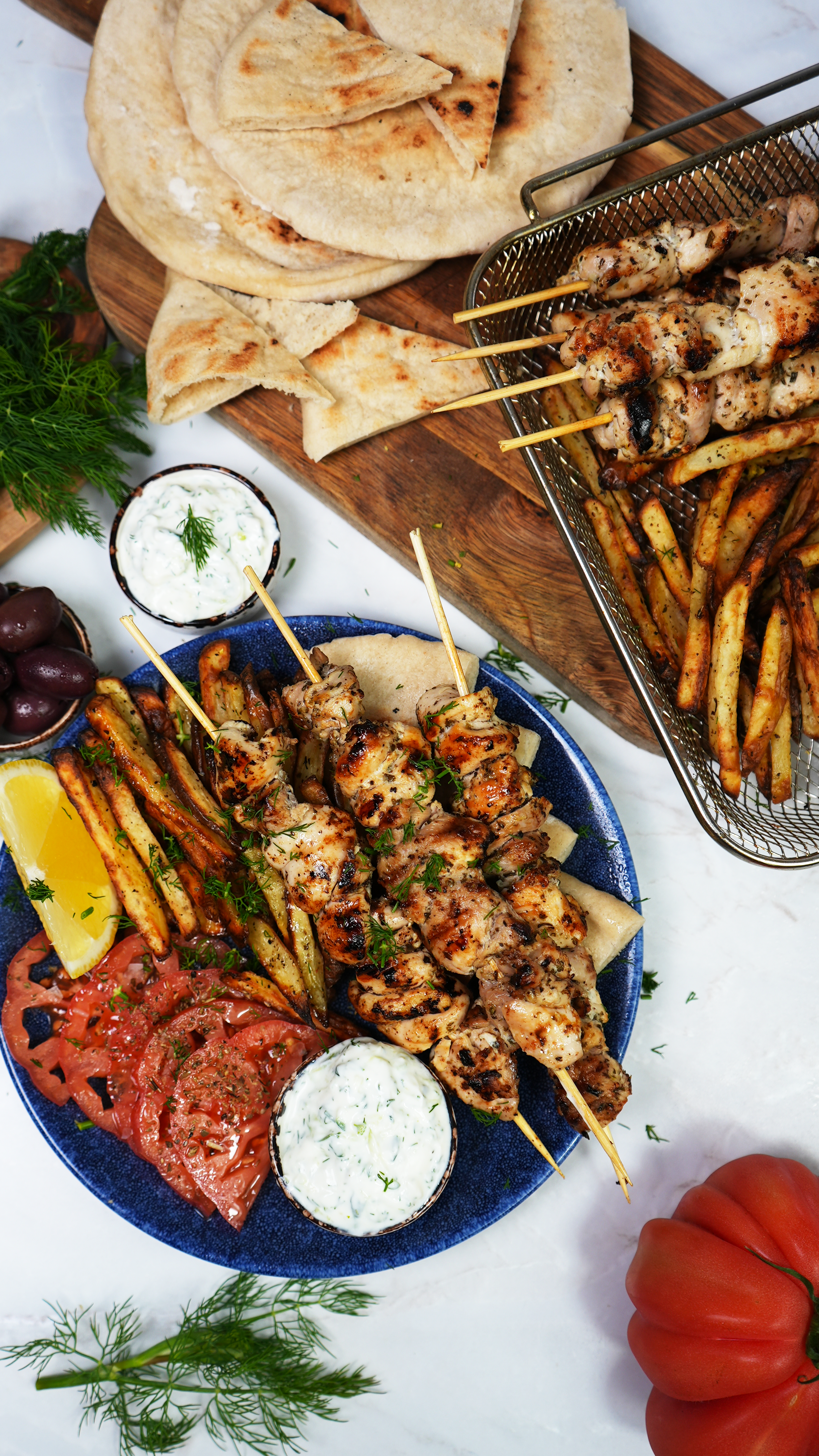 Greek chicken souvlaki skewers served on a plate with garnishes.