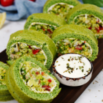 Spinach Chopped Salad Roll sliced and served on a board, showcasing a colourful filling of shrimp, avocado, and vegetables.