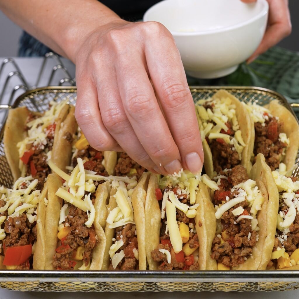 Assembling Tacos with Beef Filling and Cheese