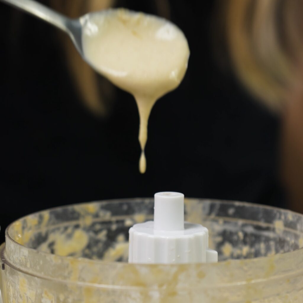 Blended tahini sauce in a food processor.