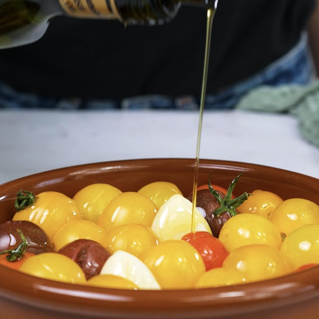 Cherry tomatoes seasoned with garlic and thyme, ready for roasting.