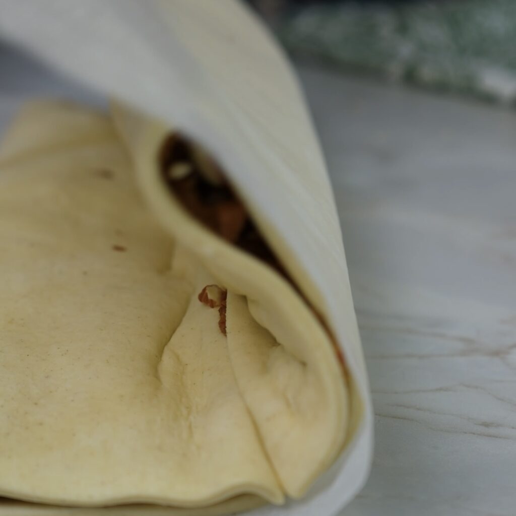 Folding puff pastry in half to form a rectangle.