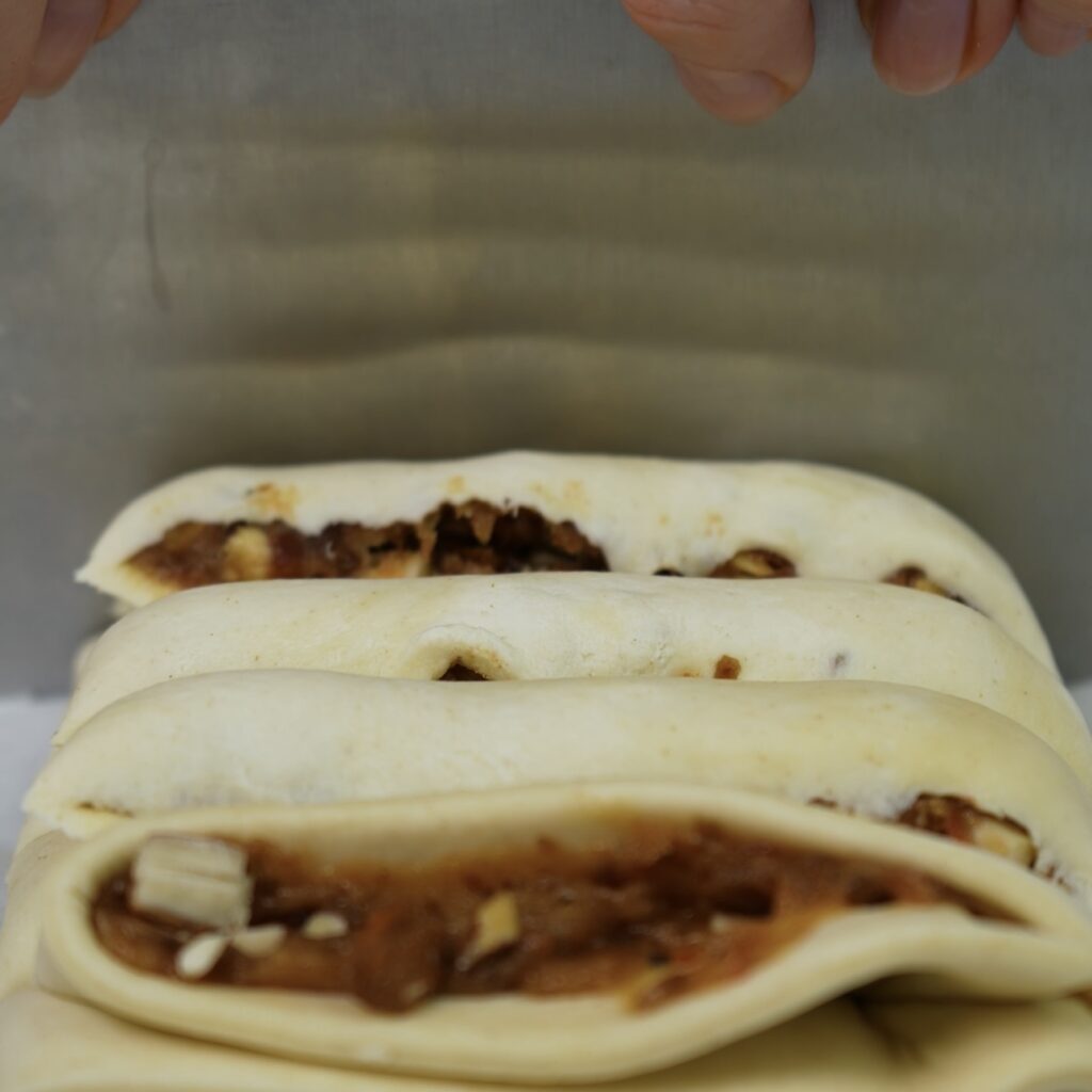 Cutting puff pastry into 2cm strips.