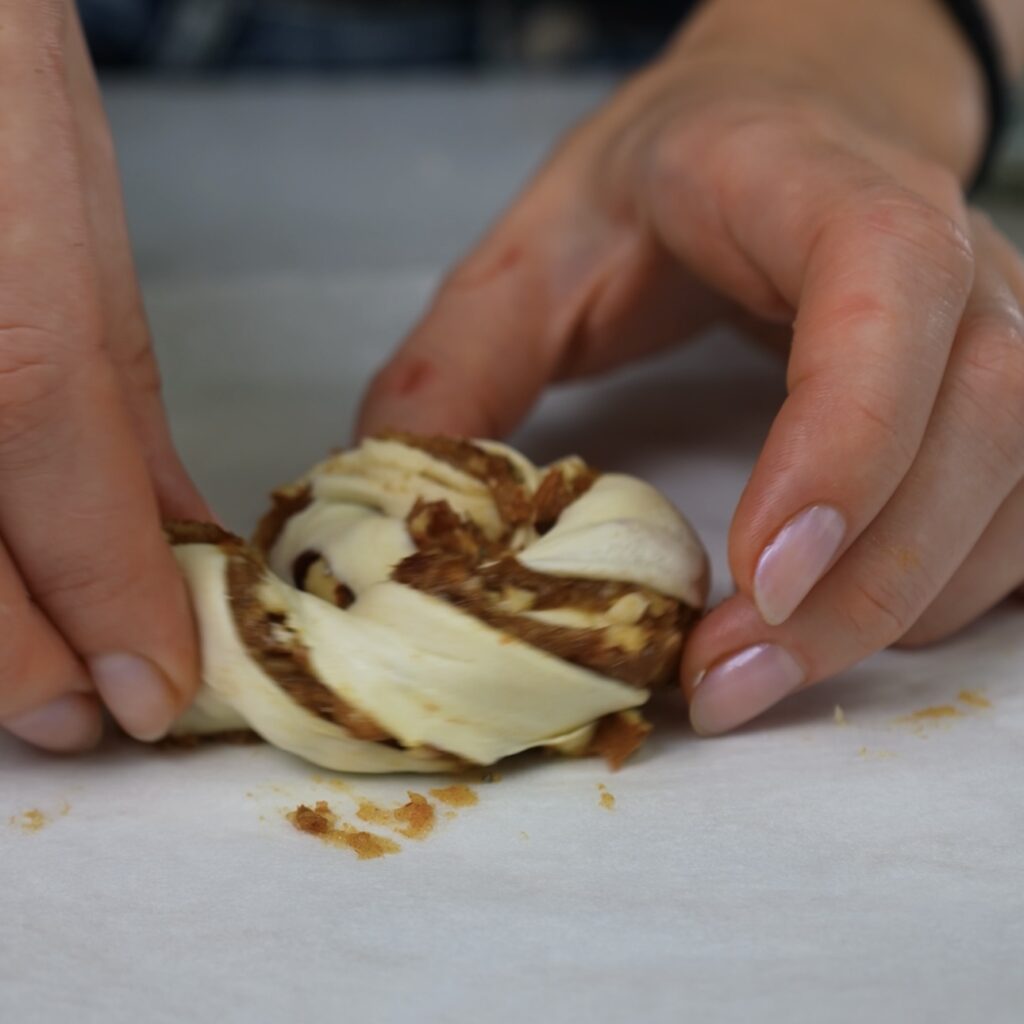 Shaping twisted puff pastry strip into a spiral.