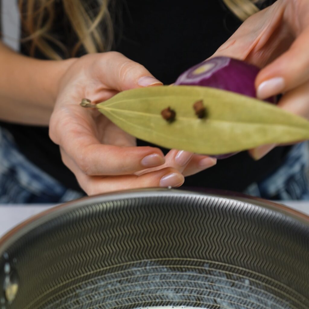 Bay leaf secured to an onion with cloves.