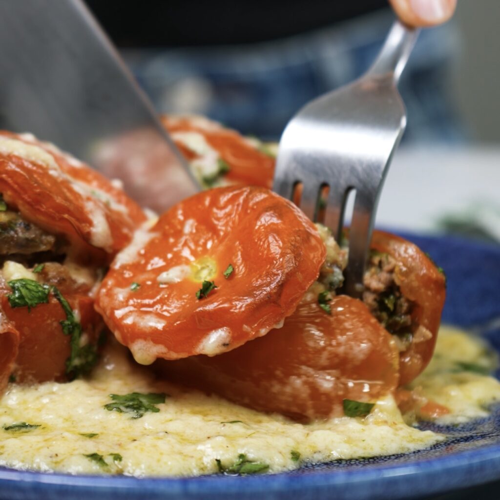 Cut stuffed tomatoes served on a plate.