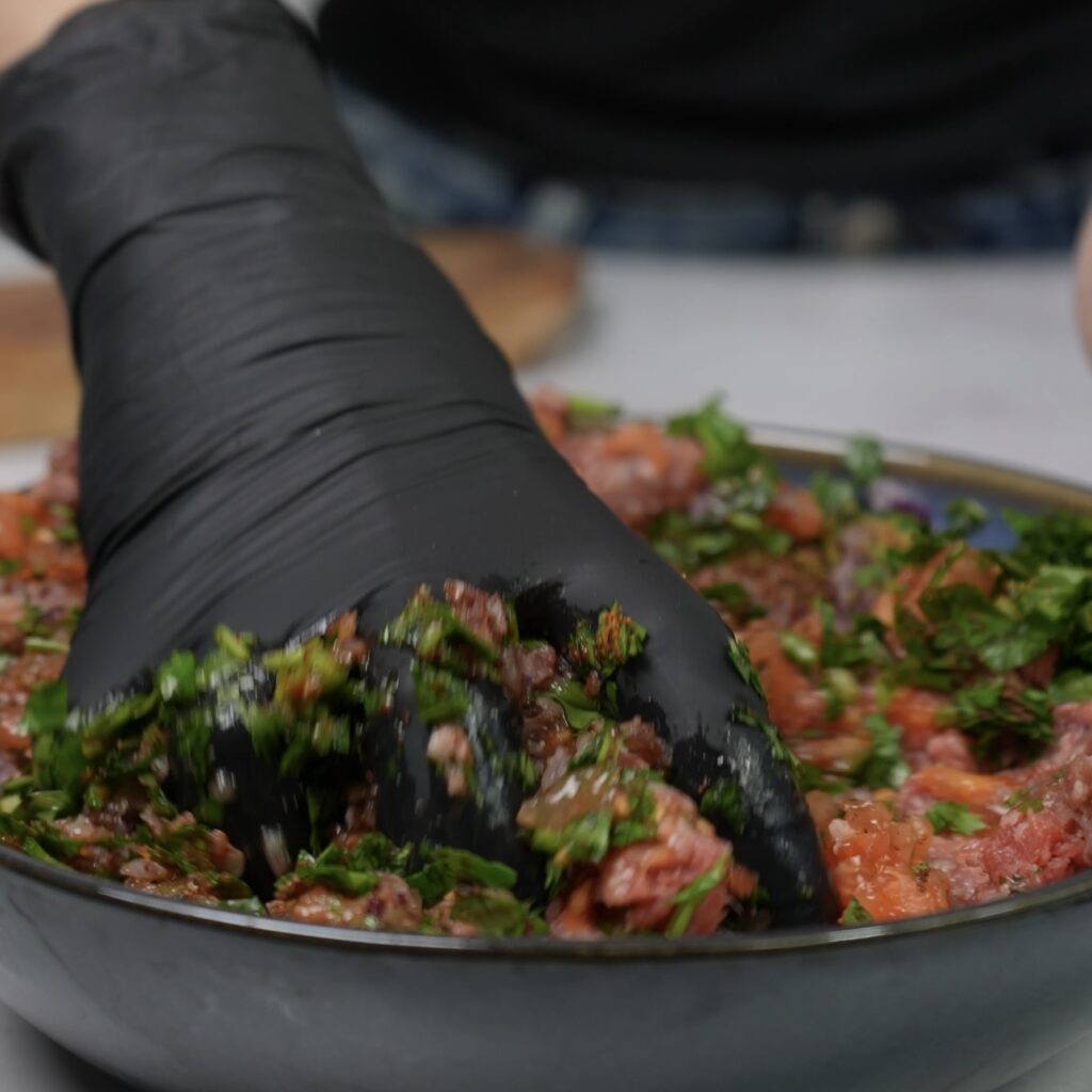 Mixing filling for stuffed tomatoes.