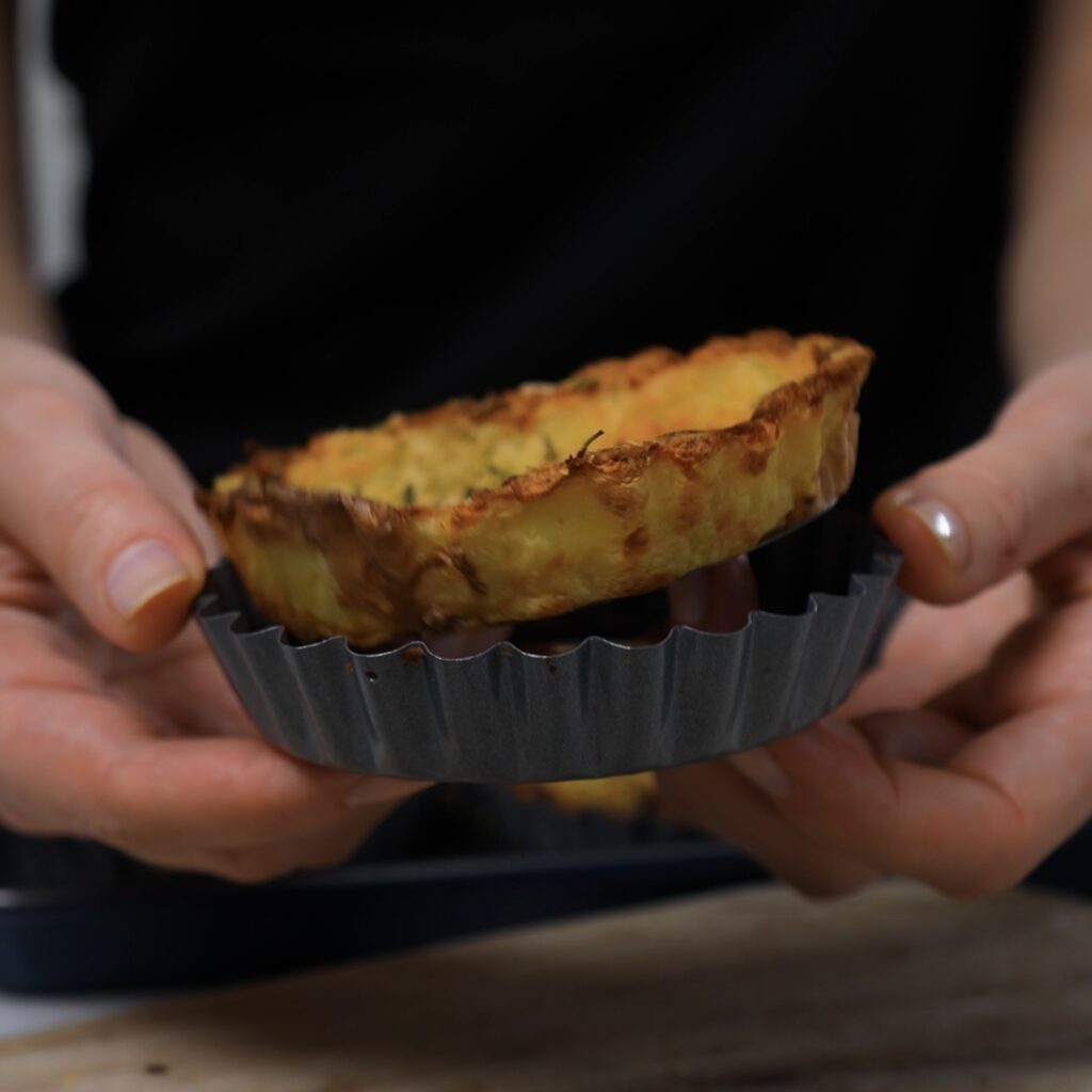 Removing Mini Crushed Potato Tart from a loose-bottom tart tin.