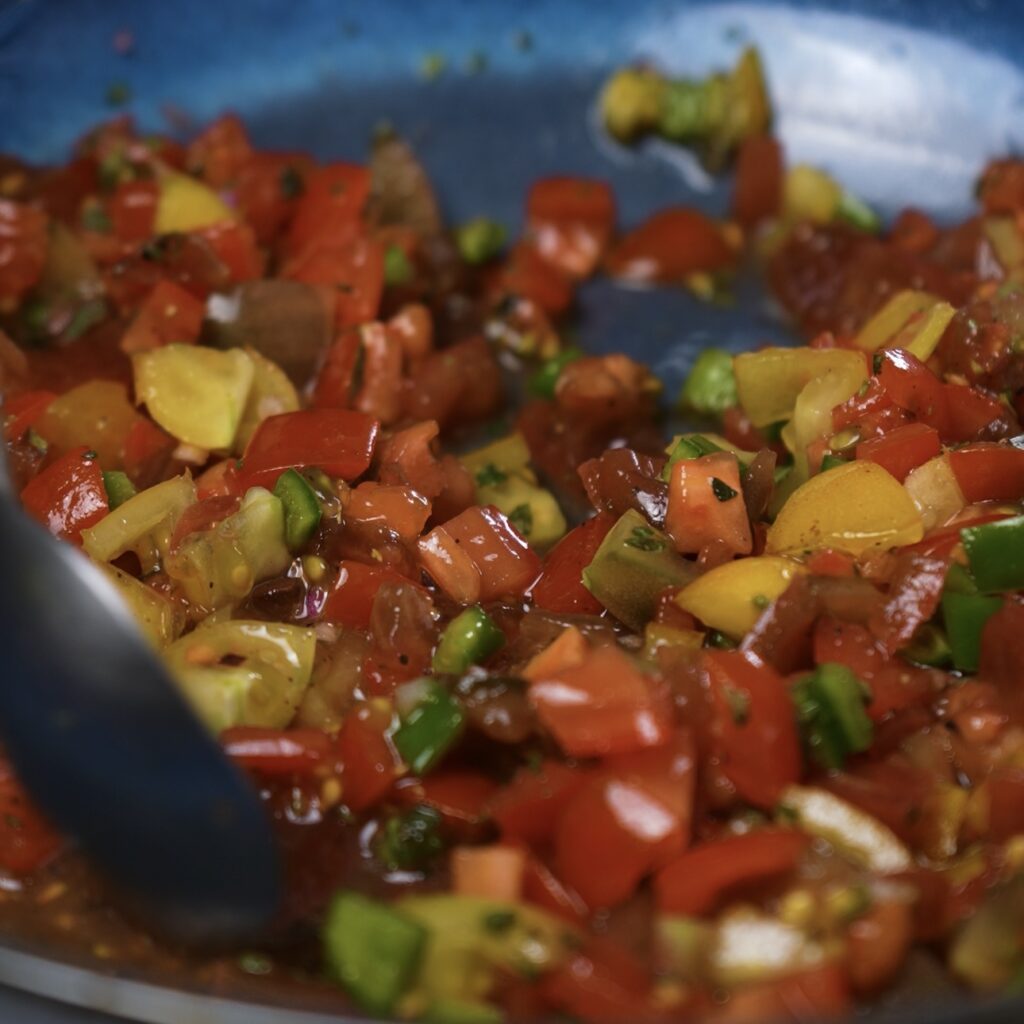 Combining ingredients for tomato salsa.