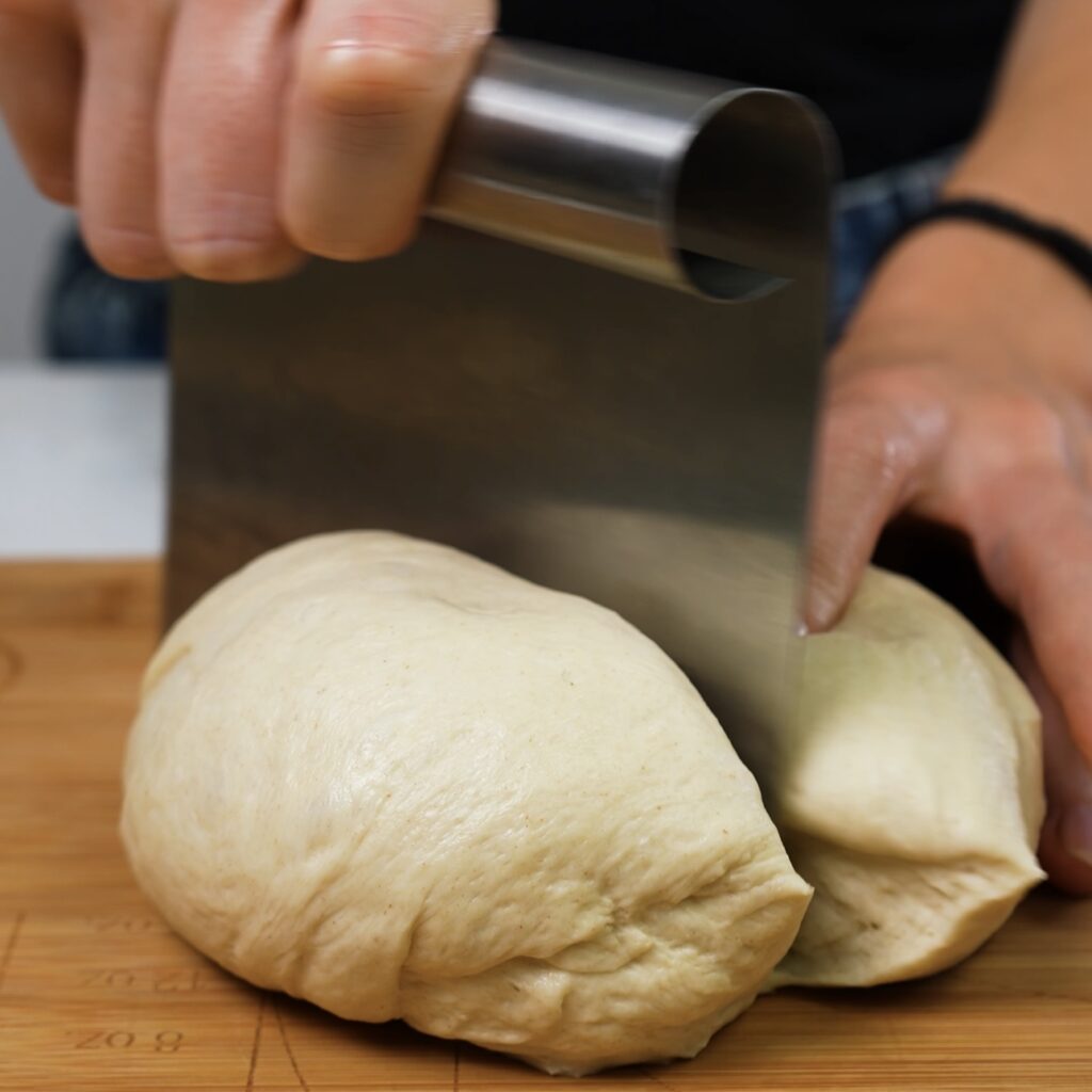 Dividing risen dough into two equal pieces.