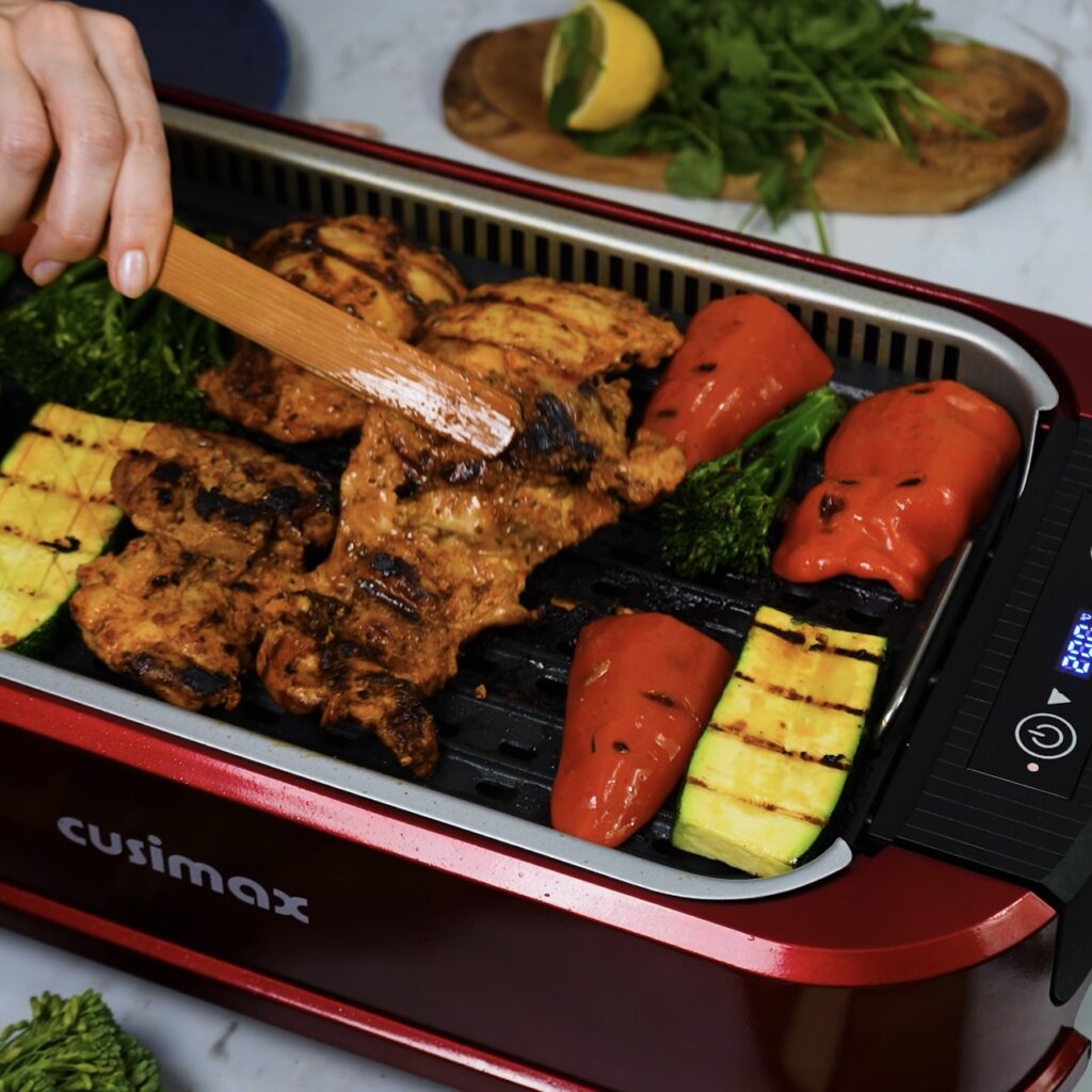 Grilling marinated Harissa chicken and colourful veggies on a Cusimax electric grill.