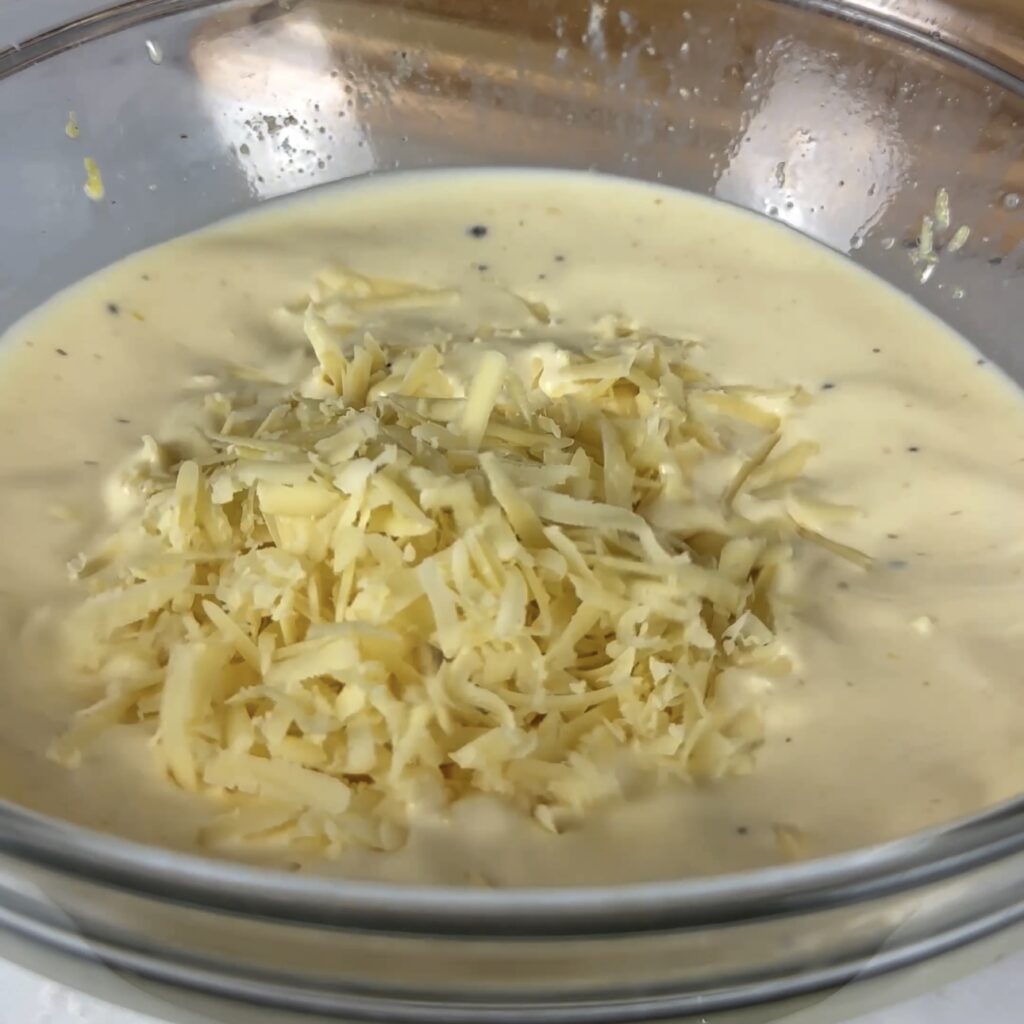 Whisking eggs, cream, and Gruyere cheese for quiche filling