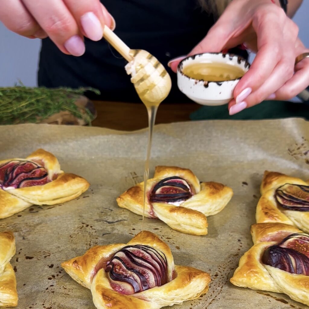 Drizzling honey over freshly baked fig puffs.