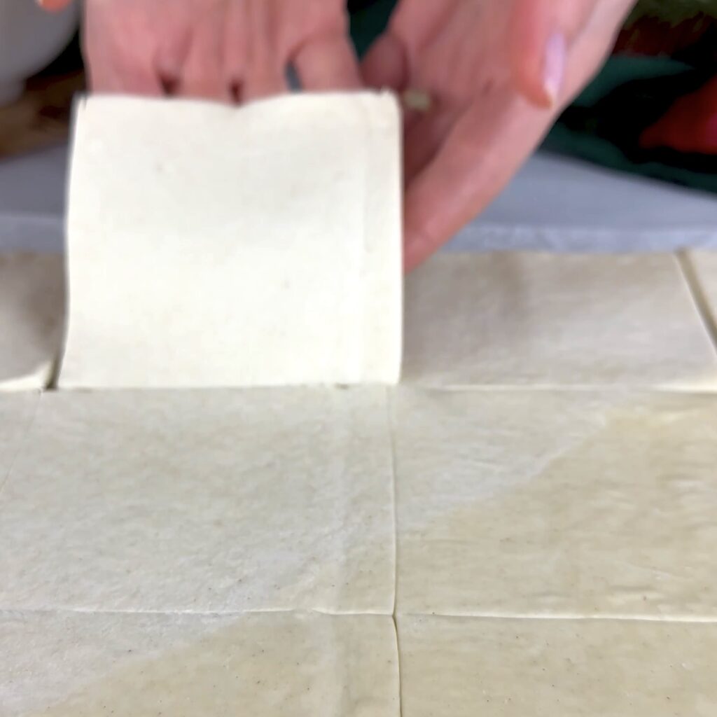 Puff pastry cut into equal squares ready for shaping.