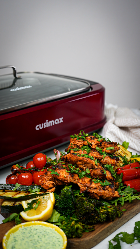 Grilled Harissa Chicken thighs served with colourful grilled veggies.