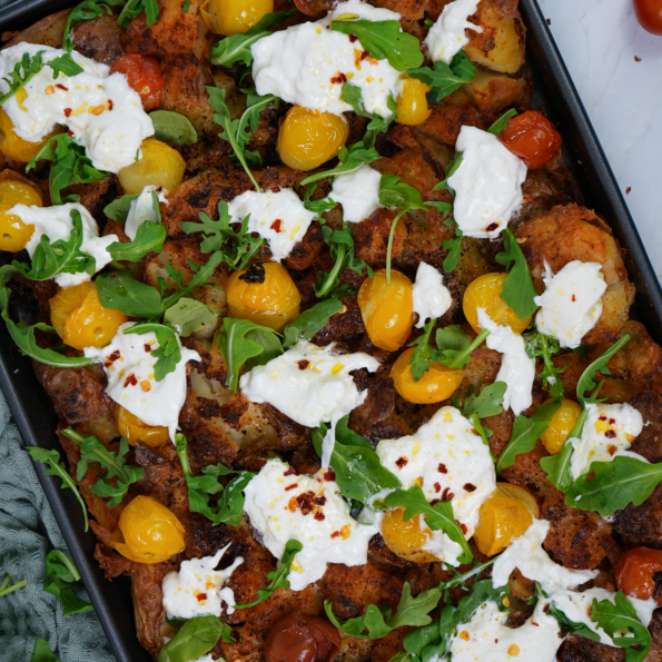 Loaded Crushed Potatoes with roasted tomatoes, fresh rocket, and torn burrata.