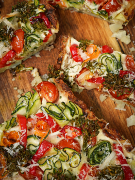 A beautifully sliced Crushed Potato Veggie Quiche, revealing a creamy filling and assorted vegetables in a potato crust.