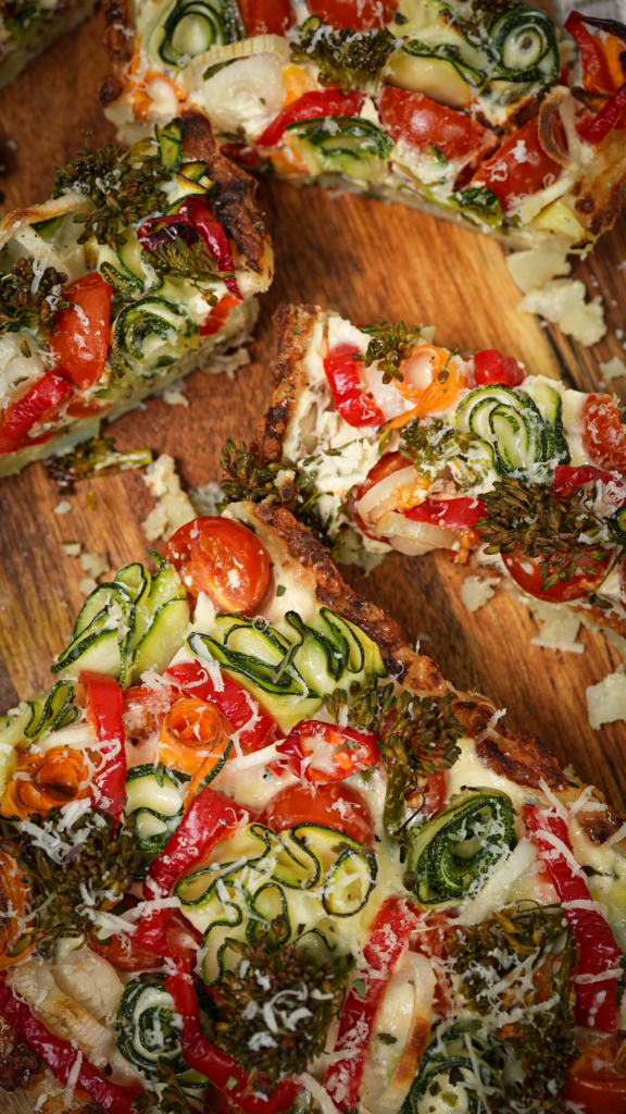 A beautifully sliced Crushed Potato Veggie Quiche, revealing a creamy filling and assorted vegetables in a potato crust.