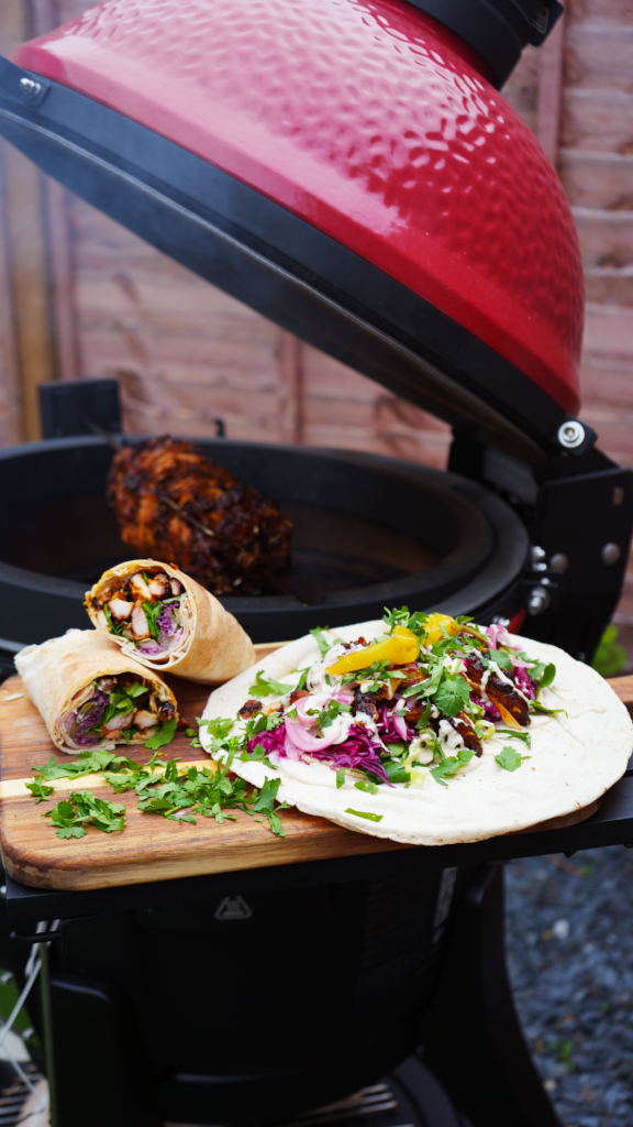 Chicken Shawarma served with pita and fresh vegetables, cooked on a Kamado Joe grill.