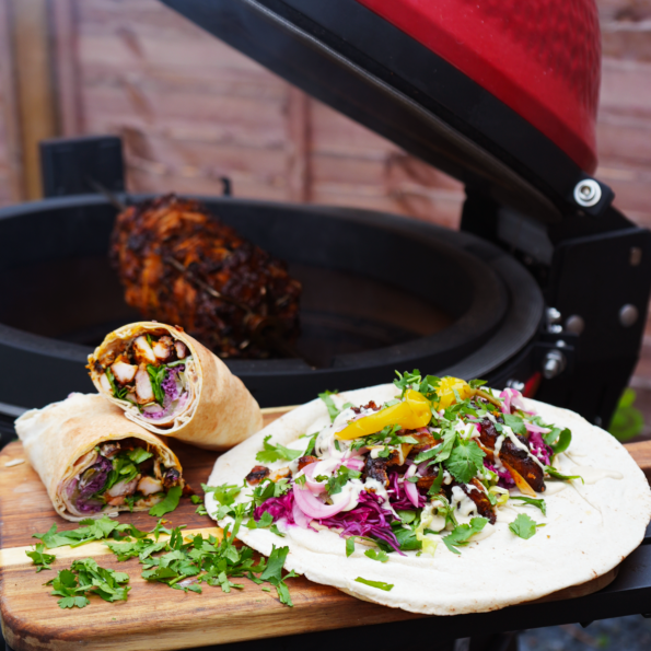 Chicken Shawarma served with pita and fresh vegetables, cooked on a Kamado Joe grill.