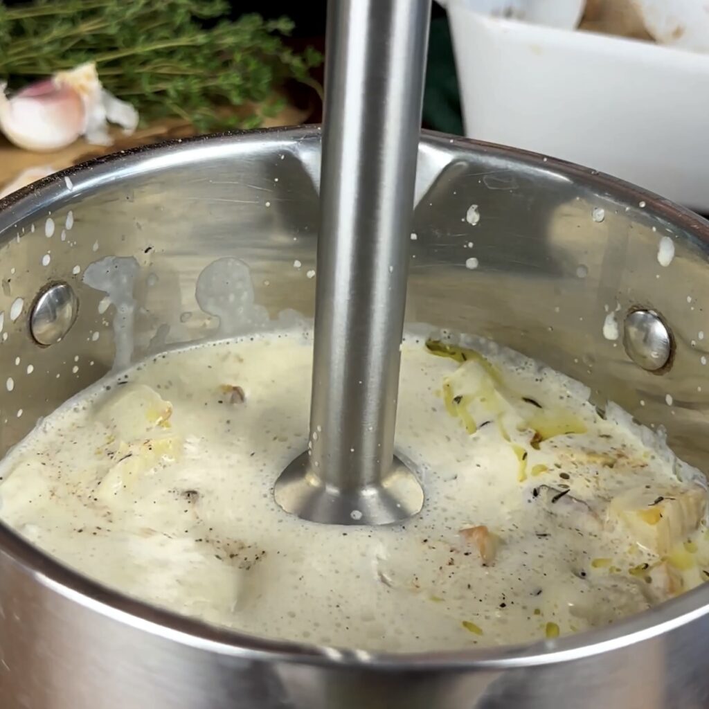 Blending the Roasted Parsnip Soup with an immersion blender in a pot.