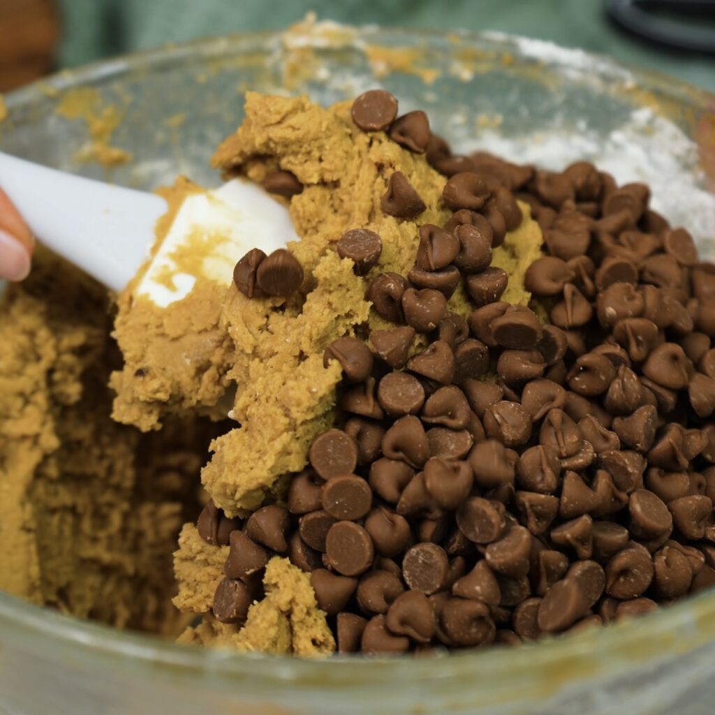 Mixing chocolate chips into cookie dough