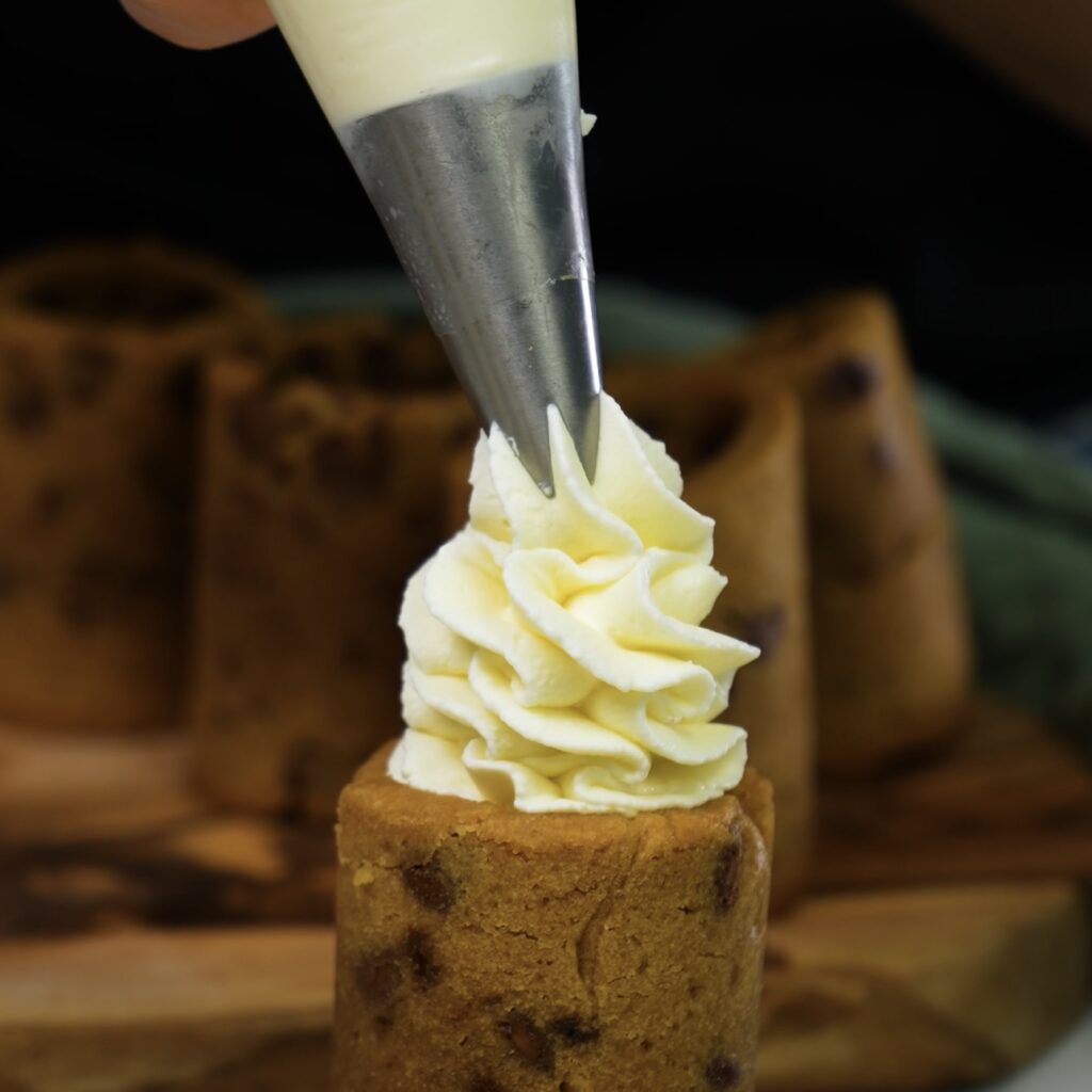 Piping cream cheese filling into cookie shot